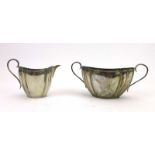 A Victorian silver two handled sugar bowl of boat shaped form, together with a matching cream jug,