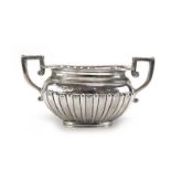 An Edwardian silver and parcel gilt two handled sugar bowl of vase shaped form with gadrooned