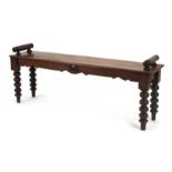 A Victorian mahogany window seat with cylindrical arms and turned legs, l.