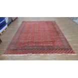 A Bokhara carpet, thre red ground with repeated motifs within matching bands,