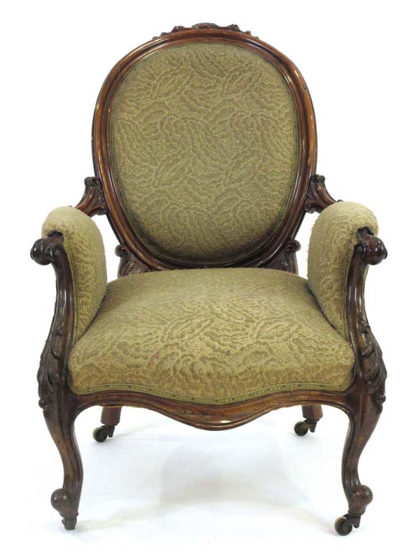 A 19th century rosewood and upholstered armchair with scrolled arms and cabriole front legs with