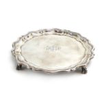 An early 20th century small silver salver with piecrust border on four claw and ball feet,