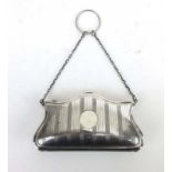An early 20th century silver coin purse with concertina interior on a finger loop chain,