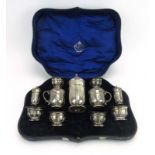 A cased silver condiments set comprising a muffineer, a pair of mustards,