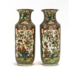 A pair of Cantonese vases of waisted cylindrical form and decorated in coloured enamels with birds