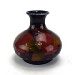 A Moorcroft miniature vase of squat bun form decorated with apples and grapes on a deep purple