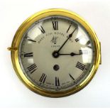 An early 20th century bulkhead clock, the face and brass case both inscribed 'Made for Royal Navy',