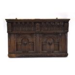 A 17th century and later panelled oak overmantle with acanthus leaf, arches and mask decoration, l.
