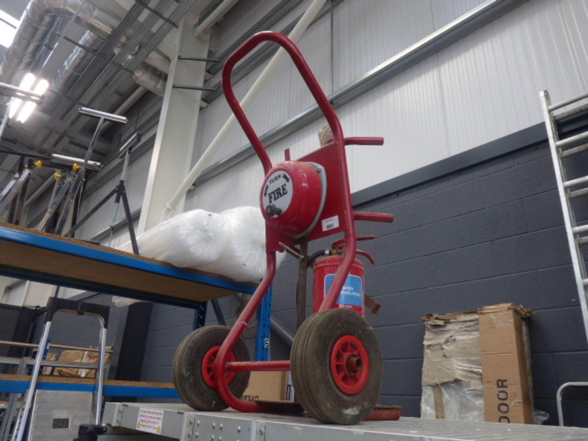 Fire bell on trolley with powder fire extinguisher.