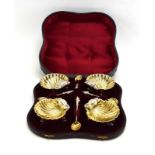 A set of four silver plated and parcel gilt salts of shell form, together with four matching spoons,