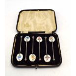 A cased set of six silver and enamelled teaspoons, each bowl decorated with a floral spray,