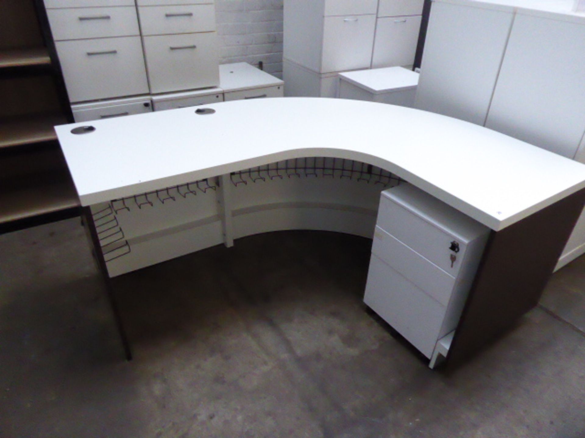 A reception corner workstation with a white top and mahogany effect surround and 3 drawer pedestal