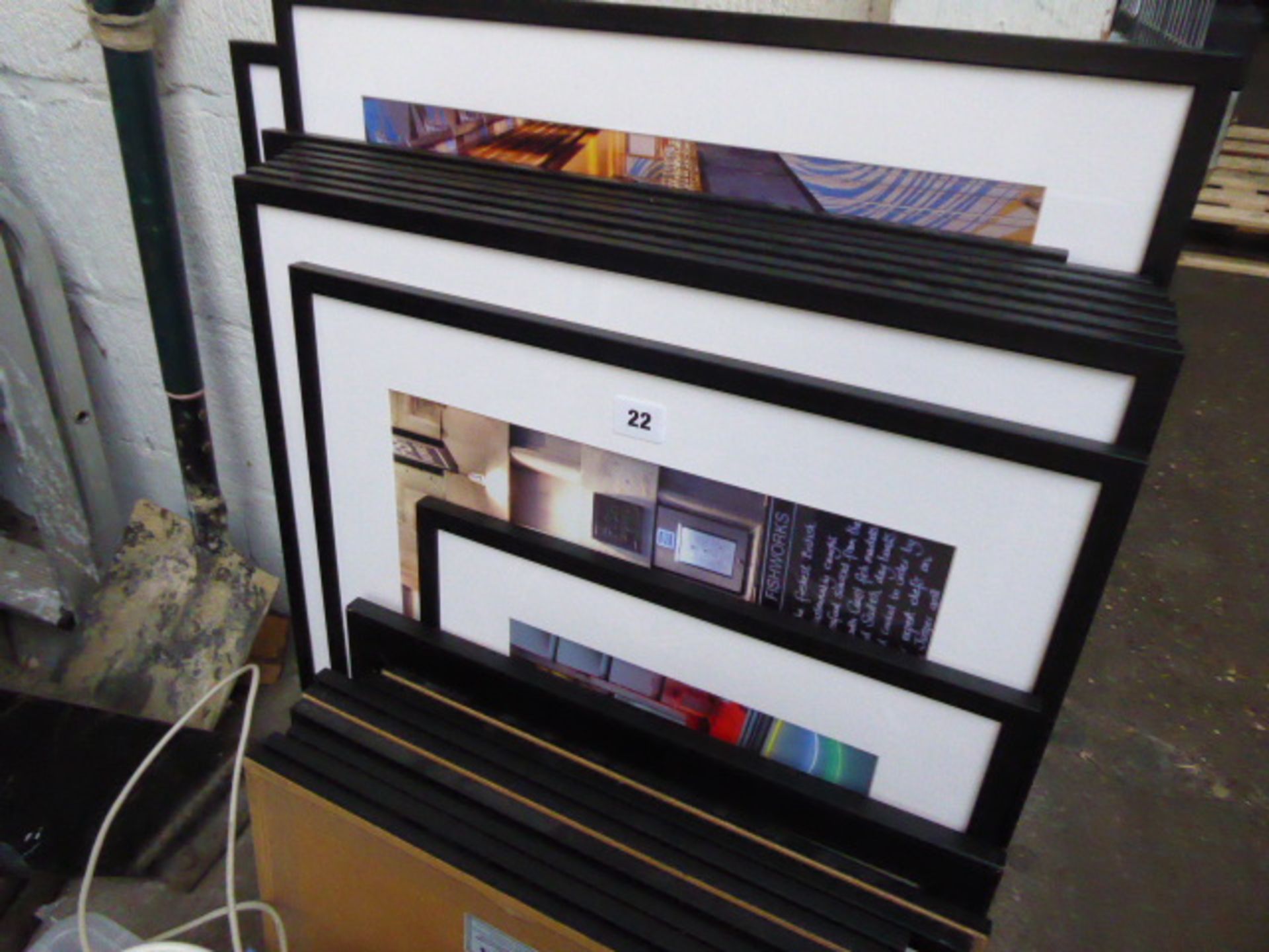 A quantity of black framed and glazed pictures with a box of extension cables