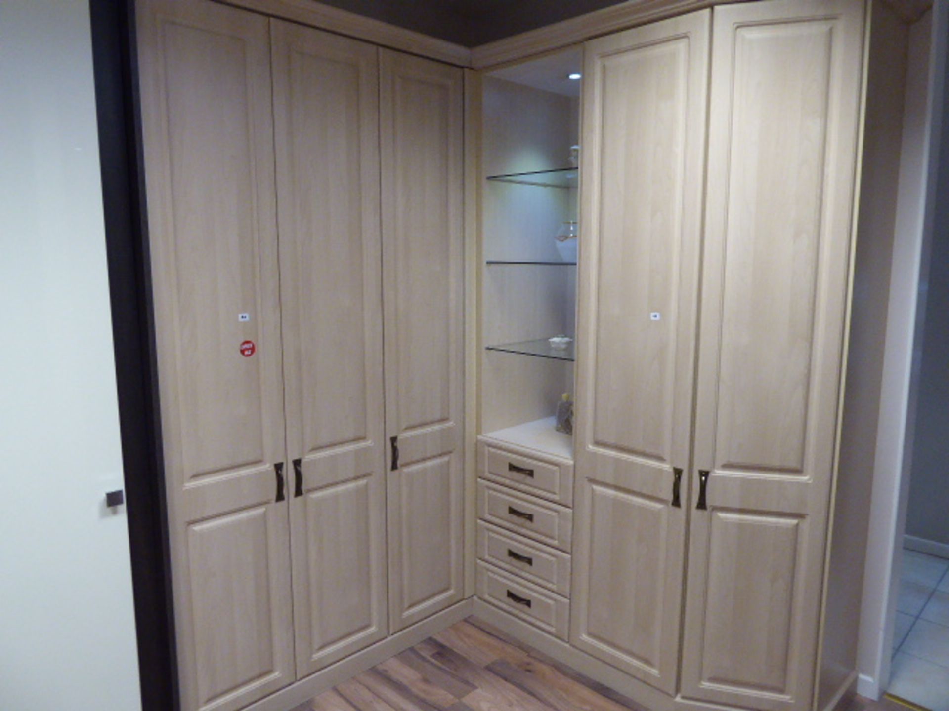 Small corner built in bedroom storage unit comprising of cupboards, drawers and open shelves. Max