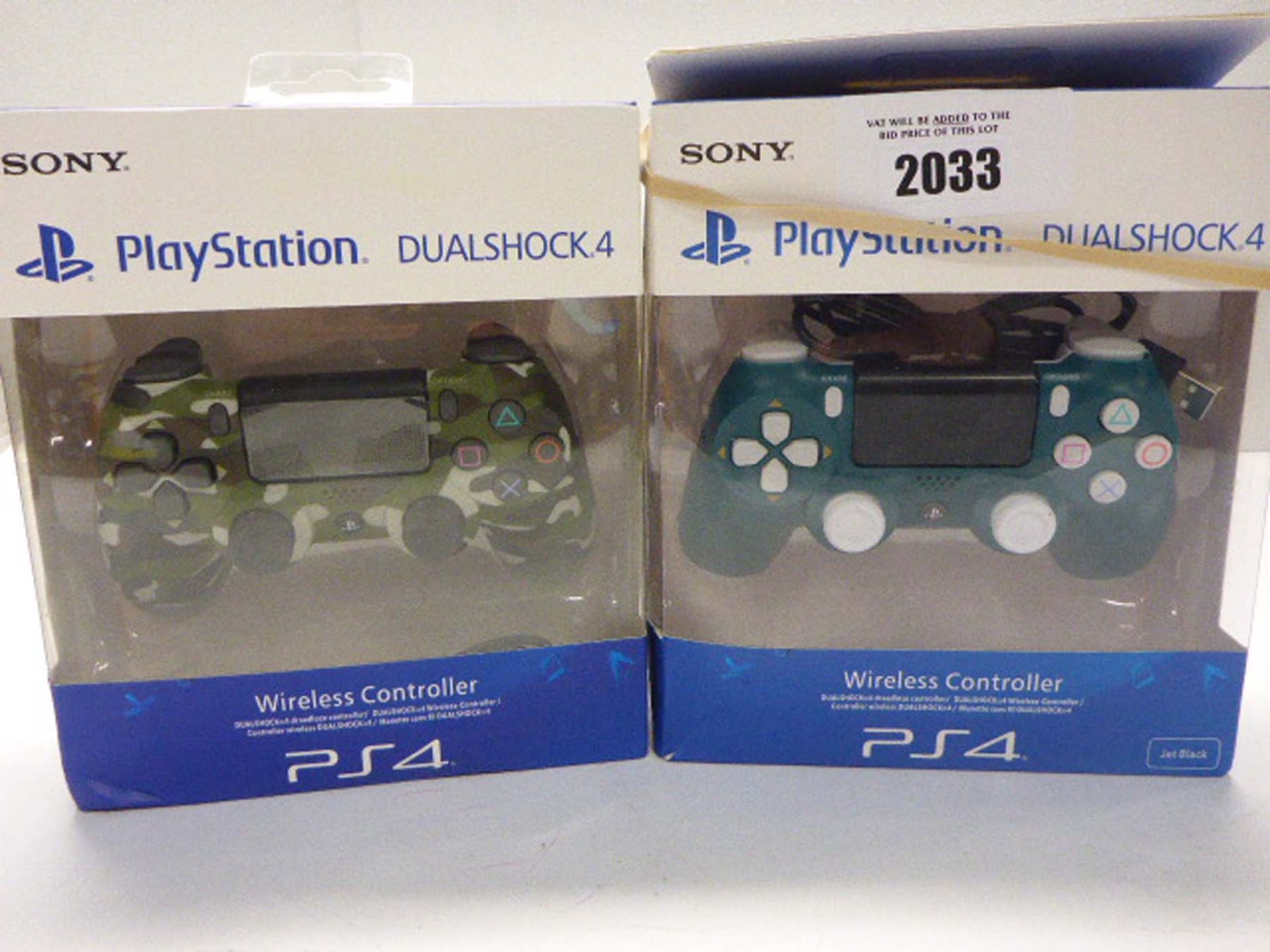 Two Sony Playstation 4 wireless controllers boxed.