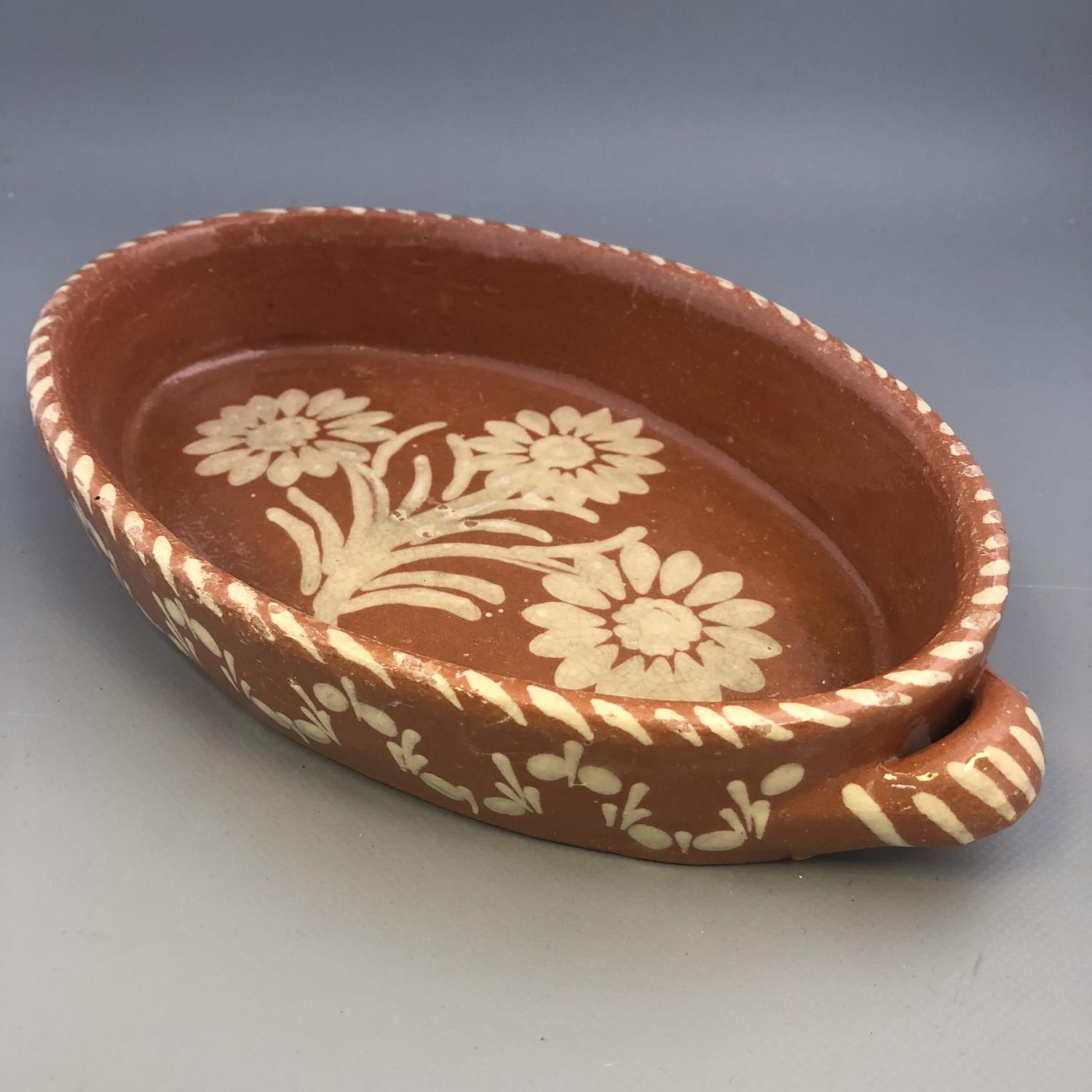 A twin handled slipware pottery dish of oval form with floral decoration - Image 2 of 5