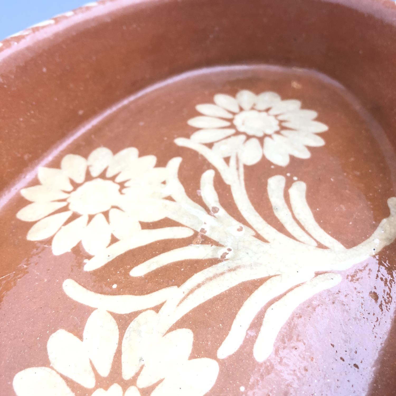 A twin handled slipware pottery dish of oval form with floral decoration - Image 4 of 5