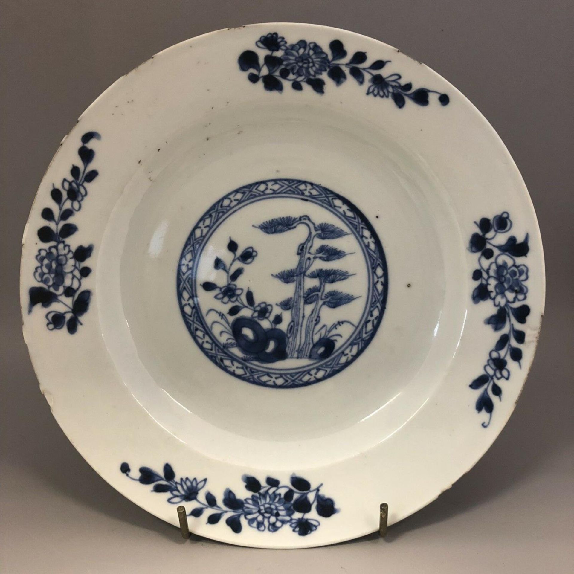 An 18th century Chinese blue and white plate with pine and flowers. No makers mark