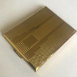 An Art Deco design engine turned gold colour powder rectangular compact by KIGU