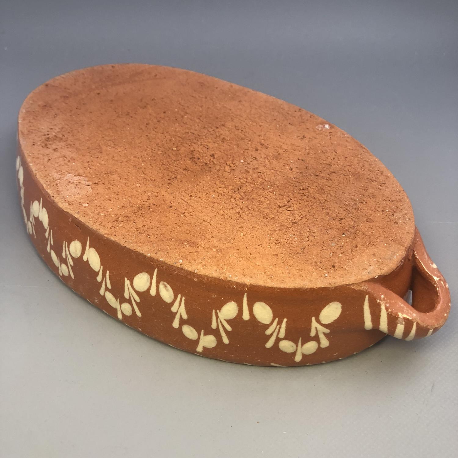 A twin handled slipware pottery dish of oval form with floral decoration - Image 3 of 5