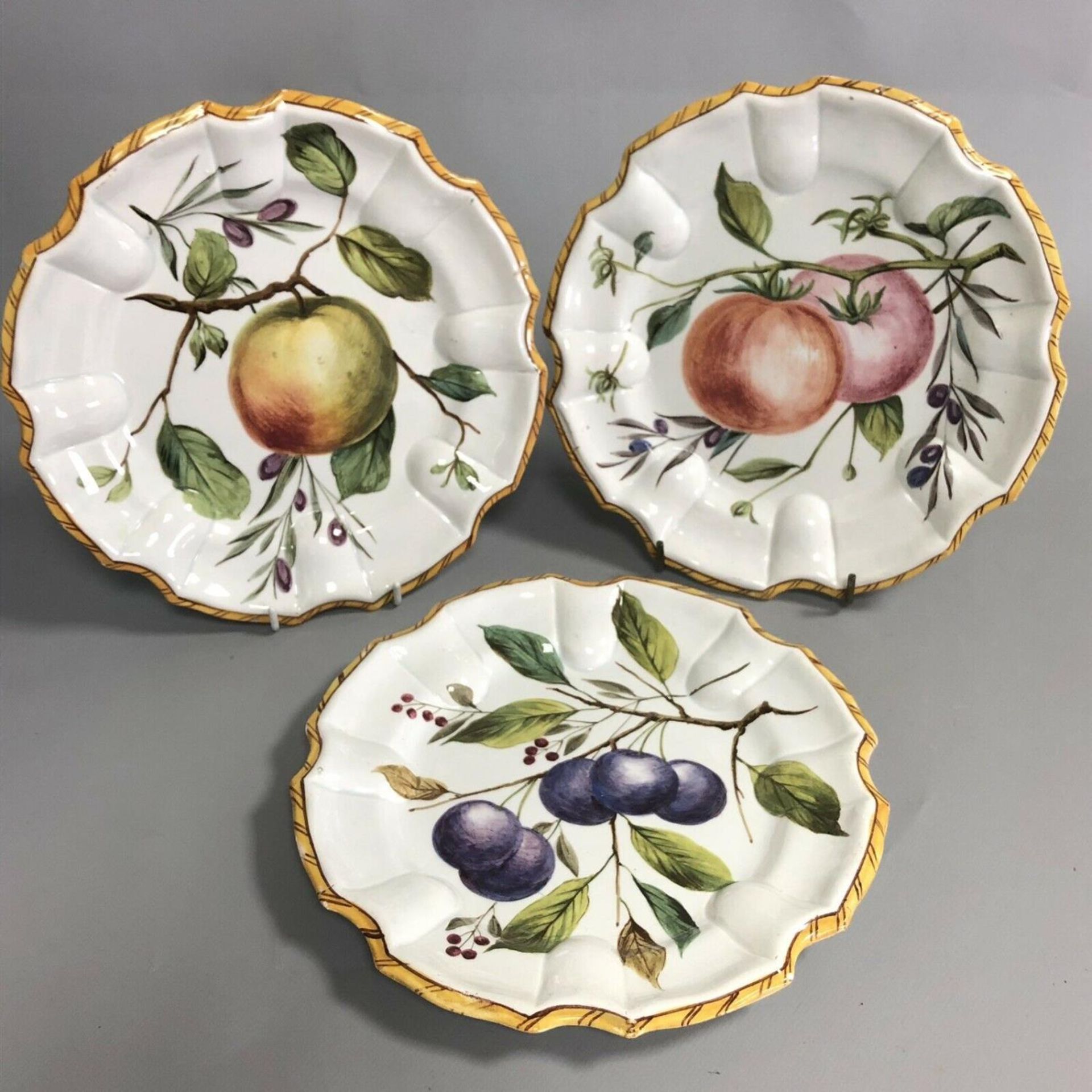 A set of three antique Continental pottery plates hand painted with fruits