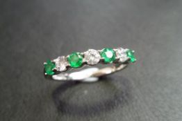 emerald and diamond seven stone band ring. 4 round cut emeralds and 3 brilliant cut diamonds. 1ct