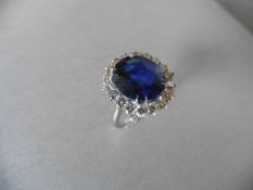 Sapphire and diamond cluster ring set in platinum. Oval cut sapphire ( fracture filled ) 6.50ct