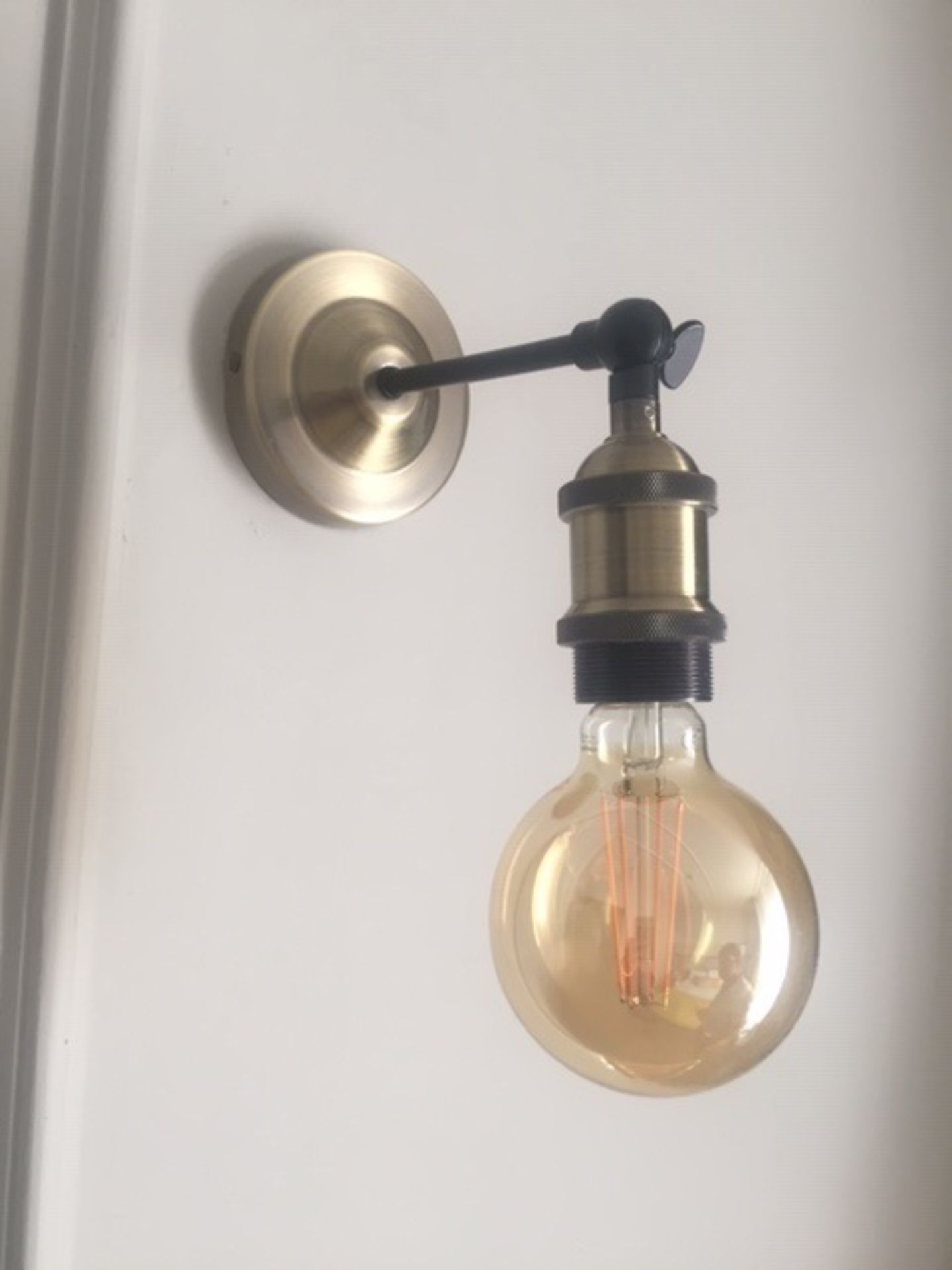 A pair of brushed gold & black wall mounted light fittings with amber led lamp. Commercial quality