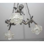 Deckenlampe, wohl Frankreich 19./20. Jahrhundert, drei Putten, die jeweils einenGlasschirm halten,