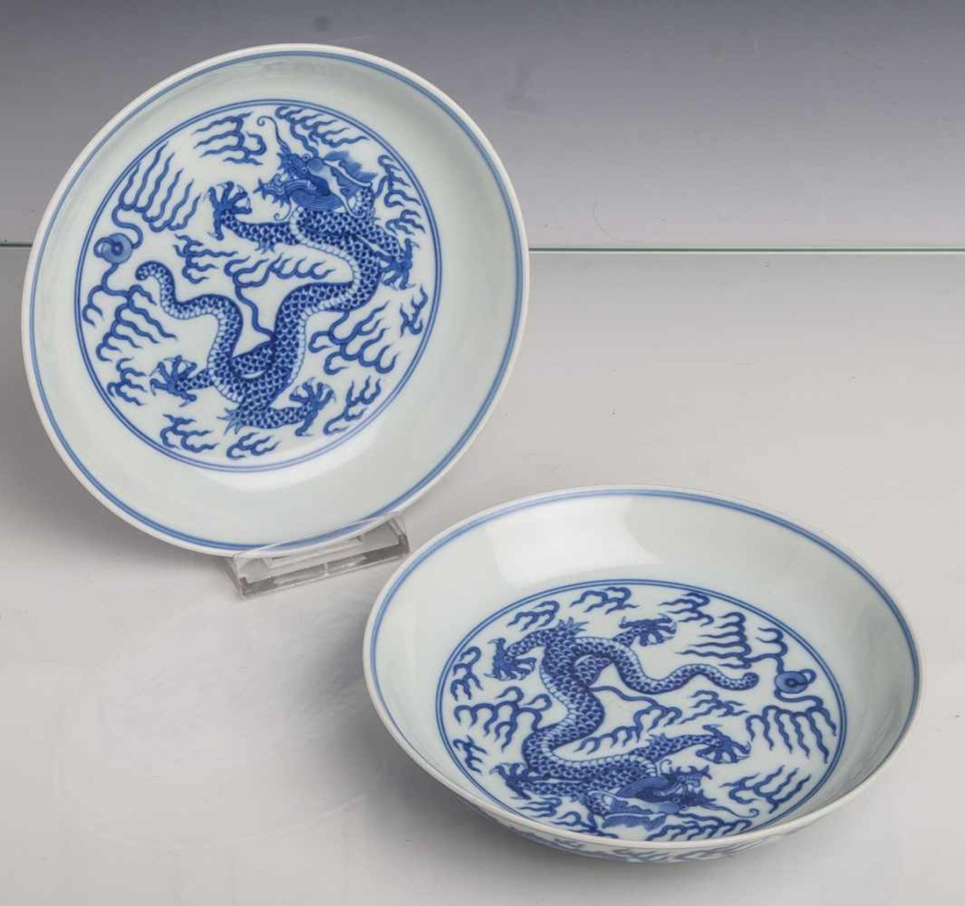 Paar Teller, China, Mitte 19. Jahrhundert, Blau-Weiß-Porzellan, mit Drachendekor. Die Us.m. blauer