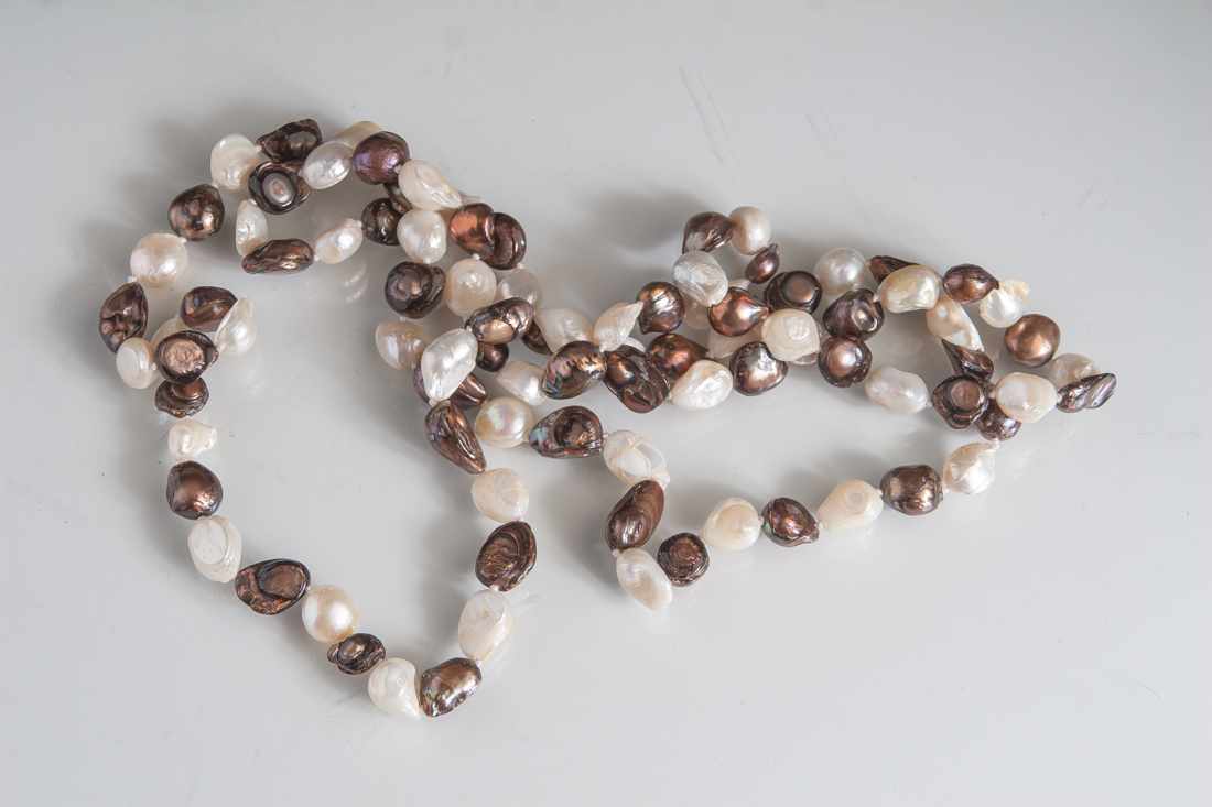 Kette aus Biwa-Perlen, endlos, aus 94 rotbraunen und crèmweißen Perlen. L. ca. 114 cm.