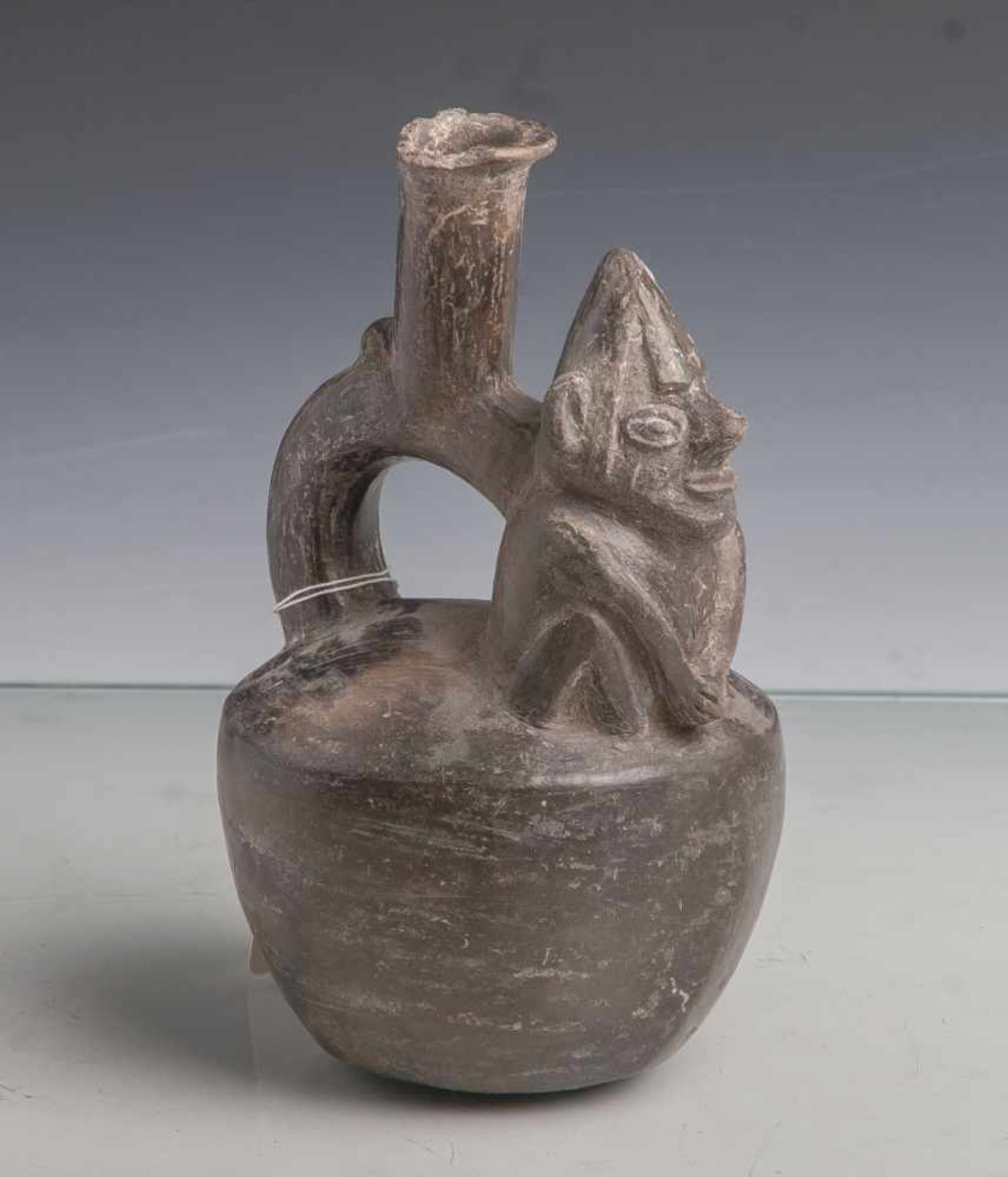 Steigbügelgefäß (Moche-Kultur), kugelförmiger Gefäßkörper, oben aufgesetzt eineaffenartige Figur,