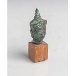 Kopf eines Buddhas (wohl Thailand), Bronze, mit Holzsockel ergänzt, H. ohne Sockel ca. 5,5cm.