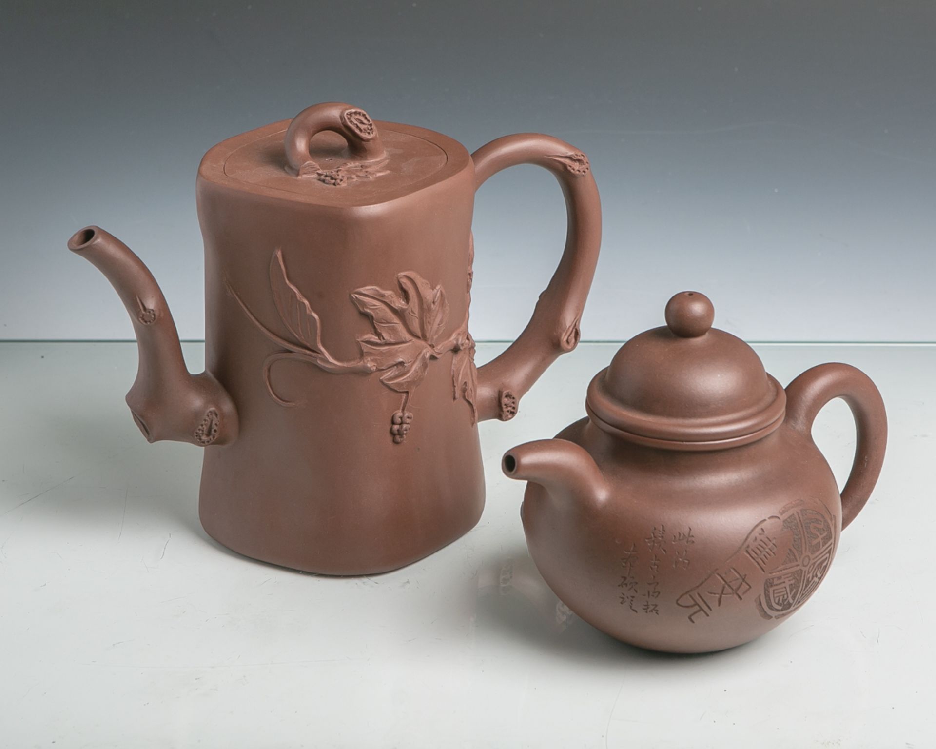 2 Teekannen aus Ton (Anf./Mitte 20. Jahrhundert), unglasiert, beide m. Bogenhenkel u.Deckeln,