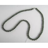 Halskette aus dunkelgrünen Jadekugeln mit Verschluss, L. ca 40 cm. Tragespuren.- - -21.00 % buyer'