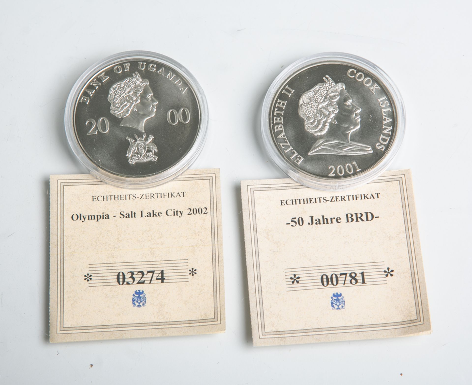 2 Sondermünzen: 1x 1000 Schillings "50 Jahre BRD" (Uganda, 2000) u. 1x 1 Dollar "ElizabethII." (Cook