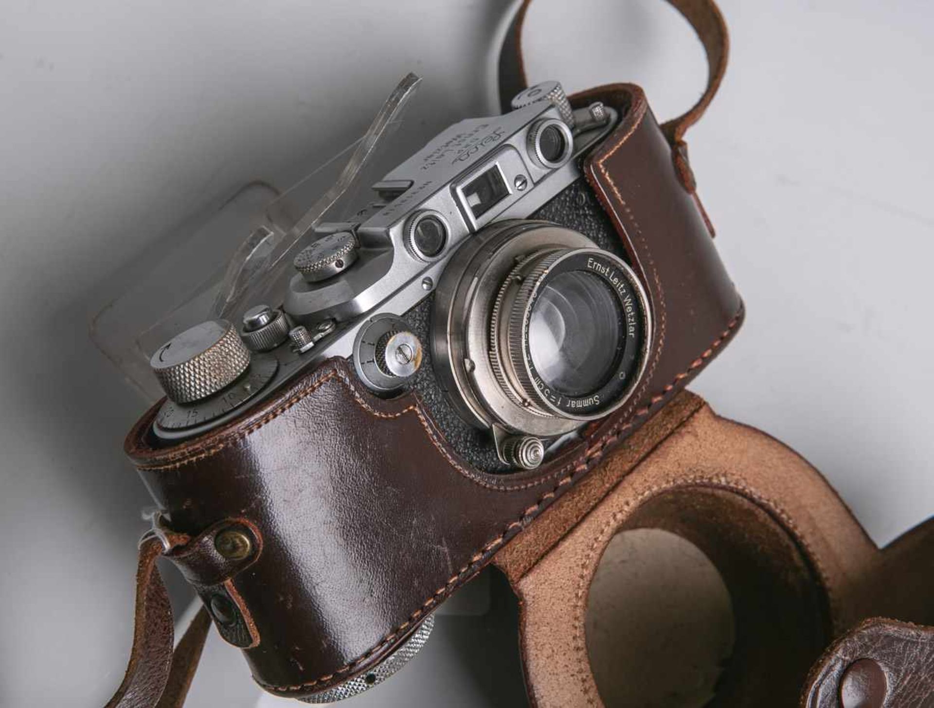 Leica-Kamera (wohl Modell III, DRP, Nr. 319518), in original Lederetui. Altersbed.Gebrauchszustand.-