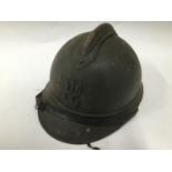 A WWII Polish Military helmet with eagle insignia, leather chin strap and green painted finish