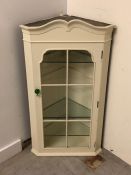 Cream painted wall corner cabinet with four glass shelves and green knob