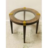 A contemporary circular side table with glass top