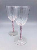 Two wine goblets with dimpled lower bowl and spiral coloured stems, One red & blue and one browner