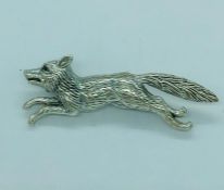 A silver brooch in the form of a fox