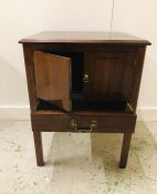 A small square cabinet on straight legs, two doors and a drawer 71cm H x 55cm W x 49cm D.