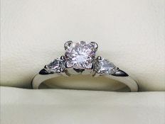 A solitaire diamond ring with diamond shoulders in a 14ct white gold setting