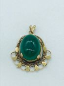 A jade pendant in yellow gold