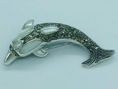 A silver and moonstone brooch in the form of a dolphin