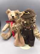 Two Teddy Bears, one with a red ribbon round its neck, one themed as an Australian Camper by