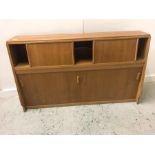 A Mid Century storage cupboard with sliding doors.