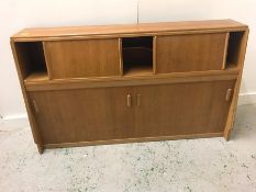 A Mid Century storage cupboard with sliding doors.