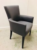 A grey upholstered occasional chair with arms